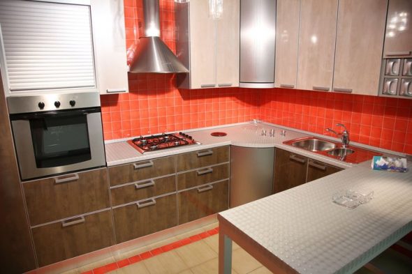 бежево-коричневый кухонный гарнитур и красный фартук