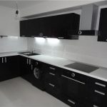 Белая столешница и черная мойка в современном кухонном интерьере
