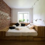 Кровать в маленькой комнате с кирпичной стеной