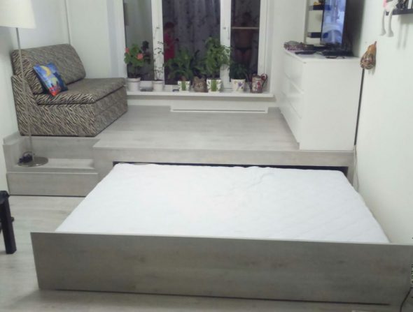 Выдвижная кровать с расположенным на подиуме диваном и телевизором