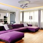 Большой фиолетовый диван в совмещенной гостиной-кухне
