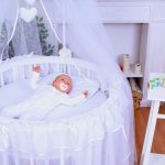 Новорожденный малыш в круглой кроватке