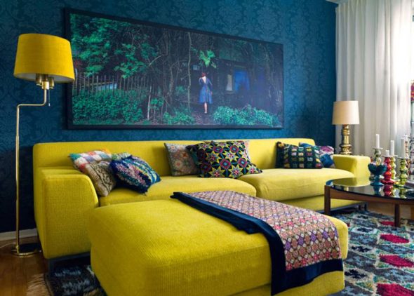 Яркий желтый диван в комнате синего цвета