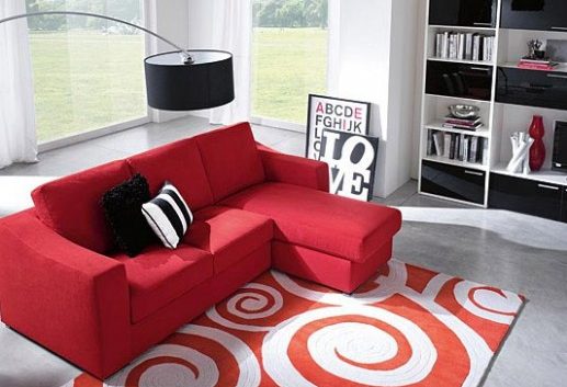 Красный яркий диван в серой комнате