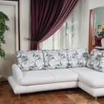 Белый угловой диван с красивыми подушками