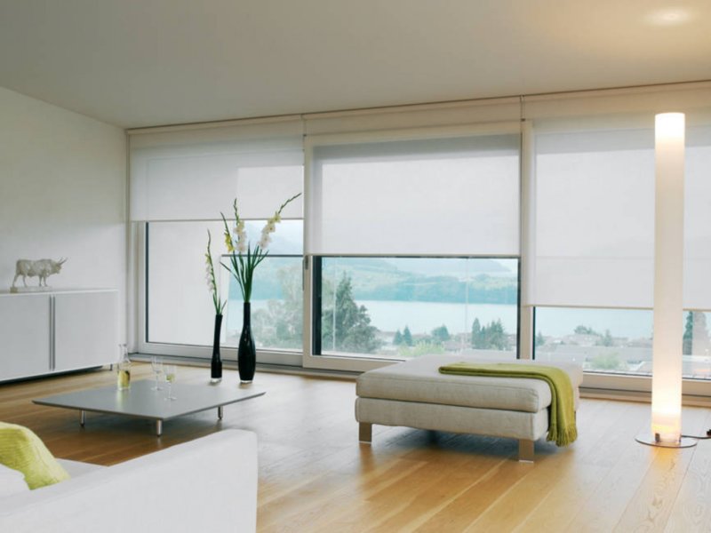 Декорирование панорамного окна гостиной рулонными шторами