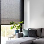 Угловой диван серого цвета перед окном гостиной