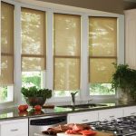 Открытые рулонные шторы на створках кухонного окна