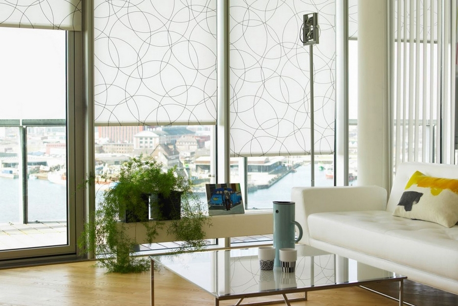 Панорамные окна гостиной с рулонными шторами из легкой ткани