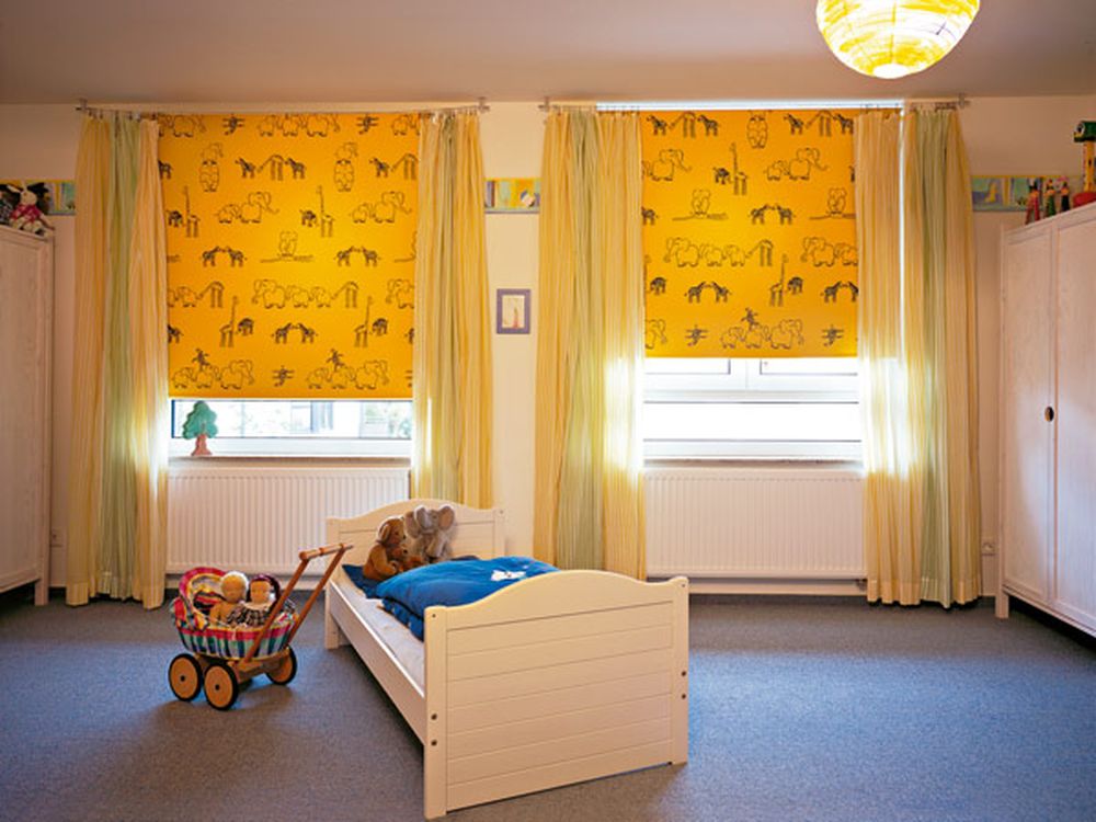 Желтые шторы с черным принтом на окнах детской комнаты