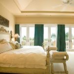 Светло-бежевая комната и яркие изумрудные шторы отличное сочетание для спальни