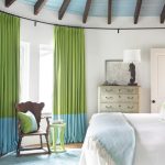Зелено-голубые шторы в интерьере спальной комнаты