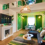 Зеленые шторы в интерьере гостиной-столовой с необычным оформлением