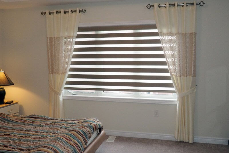 Сочетание штор зебра с прямыми шторами на окне спальни