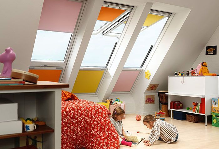Разноцветные рулонные шторы на окнах детской в мансарде