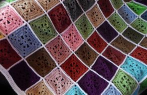 Разноцветные квадратики из остатков пряжи для яркого пледа на диван