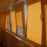 Желтые роллеты на створках балконного окна