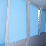 Голубые рулонные шторы на створках пластикового окна