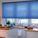 Кухонное окно с голубой рулонной шторой
