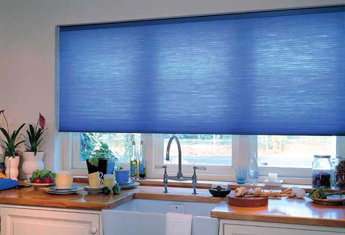 Синяя рулонная штора в проеме кухонного окна