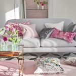 Разноцветные диванные подушки освежают интерьер серой комнаты