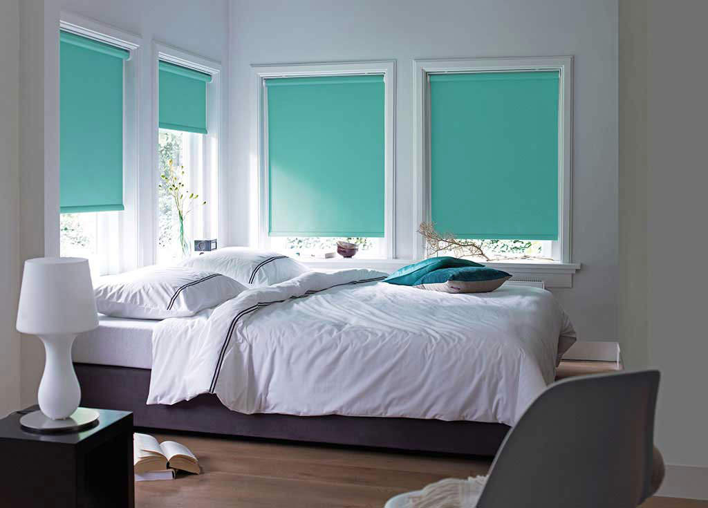 Рулонные шторы бирюзового цвета на окнах спальни