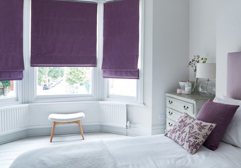 Белая спальня с римскими шторами фиолетового оттенка