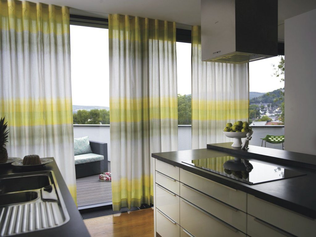 Легкие шторы с переходом на панорамных окнах кухни