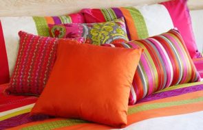 Яркие декоративные подушки в интерьере спальни