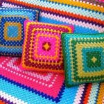 Плед и подушки на диван из разноцветных ниток в форме квадрат