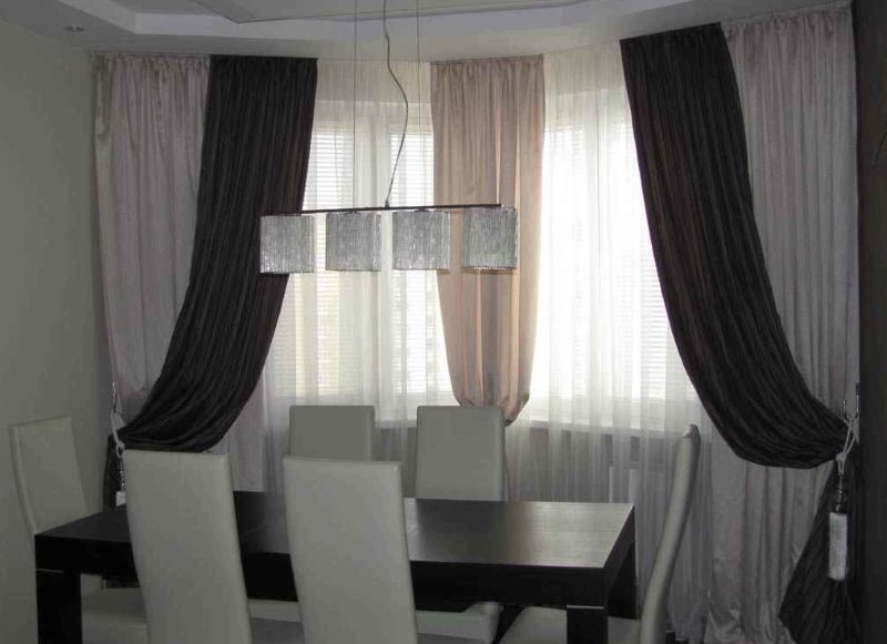 Декорирование окна гостиной плотными шторами из ткани разных цветов