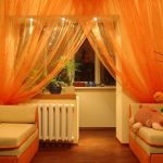 Оранжевый тюль в интерьере гостиной